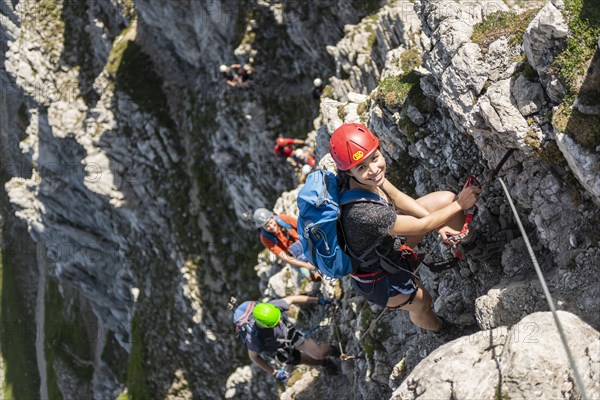 Group of mountaineers with helmet on a secured fixed rope route