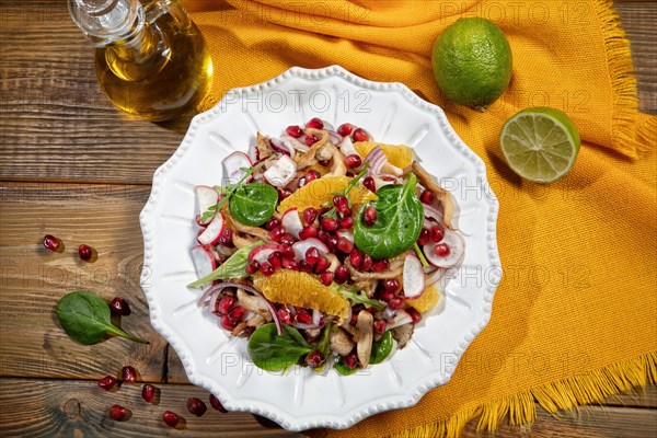 Served salad on a porcelain plate with orange slices