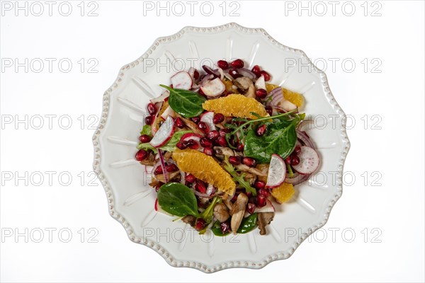 Served salad on a porcelain plate with orange slices