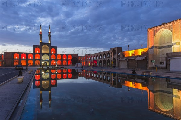 Amir Chaqmaq complex facade illuminated at sunrise and reflecting in a pond