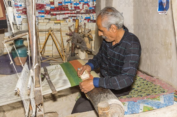 Iranian man working on a loom
