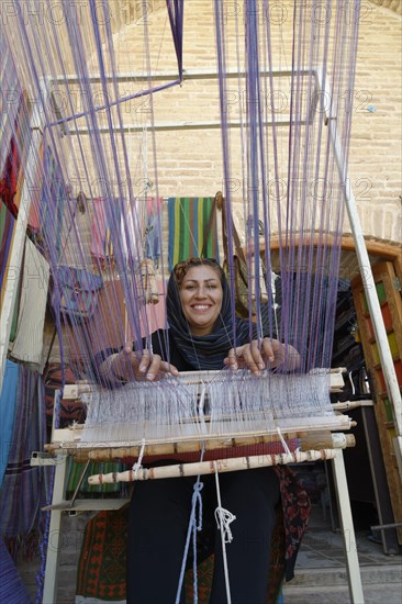 Iranian woman weaving a carpet