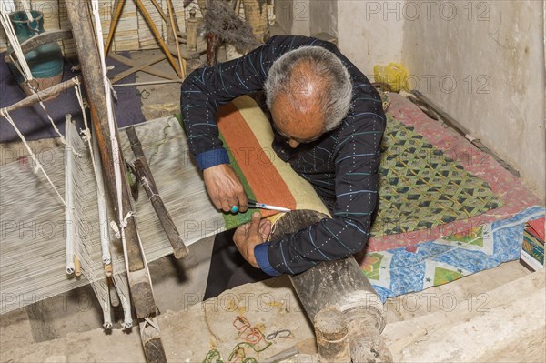 Iranian man working on a loom