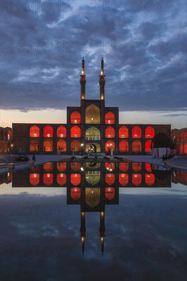 Amir Chaqmaq complex facade illuminated at sunrise and reflecting in a pond