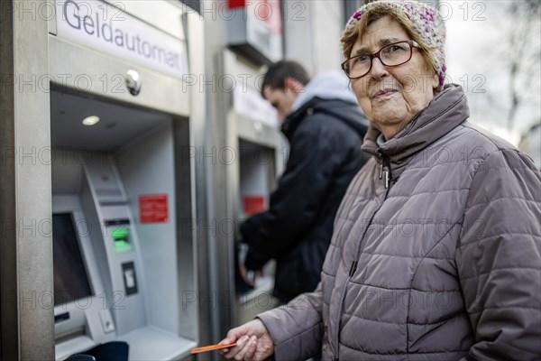 senior-citizen-with-cash-card-at-atm-looks-skeptical-photo12