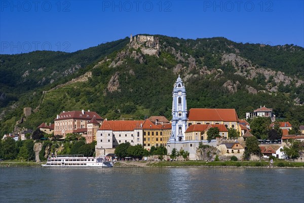 Excursion boat on the Danube in front of the baroque church of Duernstein Abbey