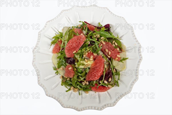 Served salad on a porcelain plate with grapefruit