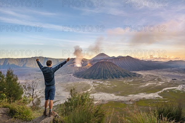 Young man stretches arms in the air