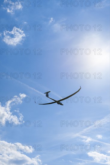 Glider about to land in a cloudy sky