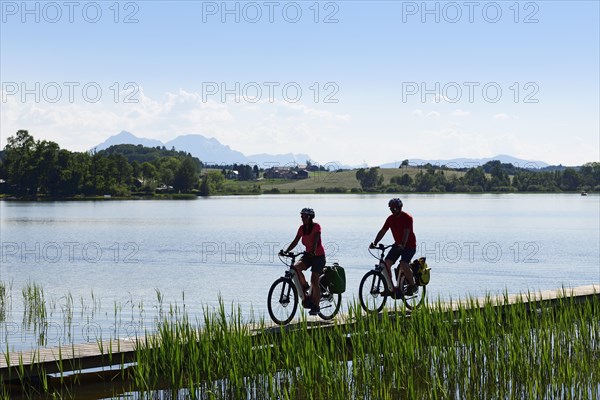 Couple with electric bikes riding on the shore