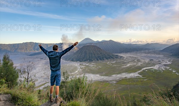 Young man stretches arms in the air