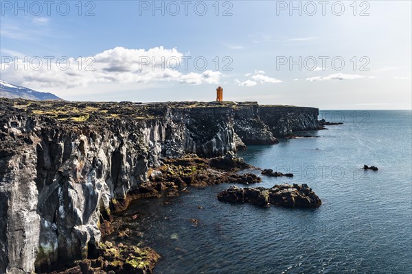 Orange lighthouse of Oendverdarnes stands on cliffs