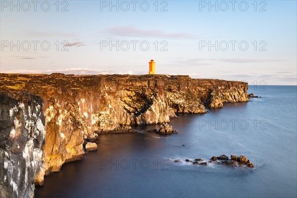 Orange lighthouse of Oendverdarnes stands at cliff coast