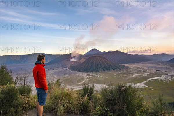 Young man in front of volcanic landscape at sunset