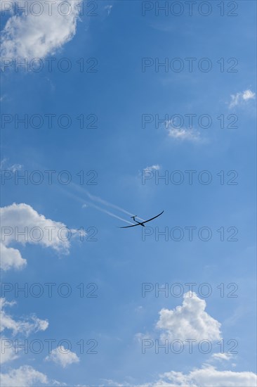 Glider about to land in a cloudy sky