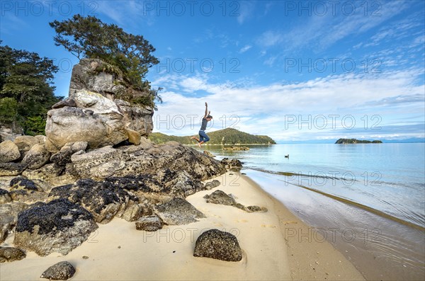 Young man jumps off a rock