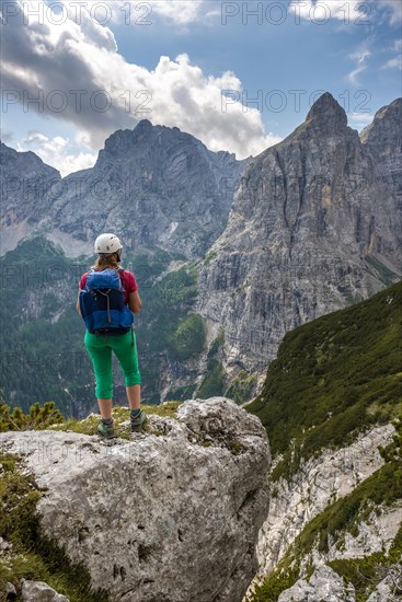 Young hiker with helmet looking at mountains