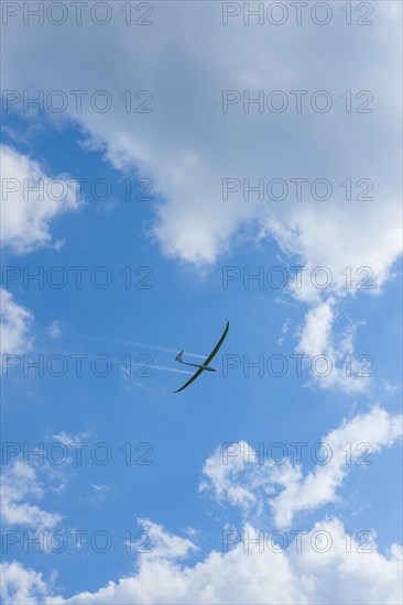 Glider about to land in a cloudy sky