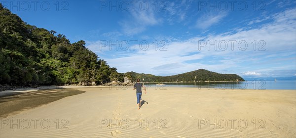 Young man walking on the beach