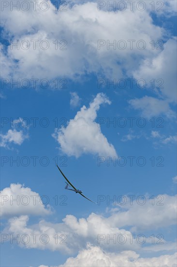 Glider flying in a cloudy sky