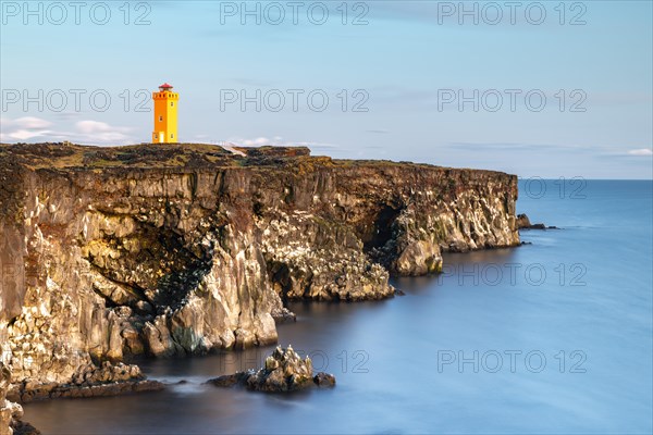 Orange lighthouse of Oendverdarnes stands at cliff coast