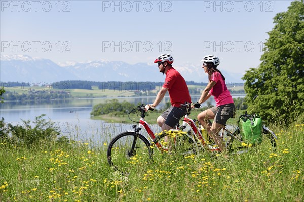 Couple with electric bikes above Lake Wallersee near Weng