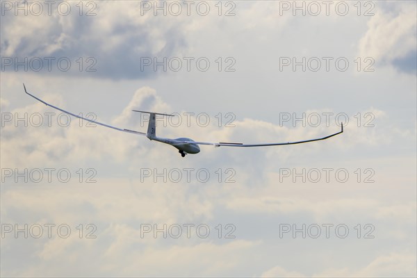 Glider flying in a cloudy sky