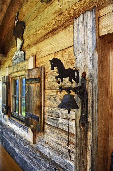 Small Swiss stone pine hut next to the mountain inn Streichen with bell made of wrought iron