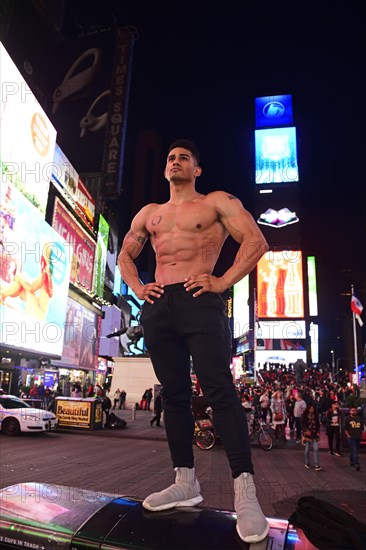 Bodybuilder gets photographed with tourists in Times Square