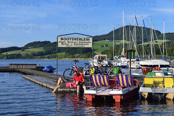 Couple with electric bikes pauses on a landing stage at Lake Obertrumer See