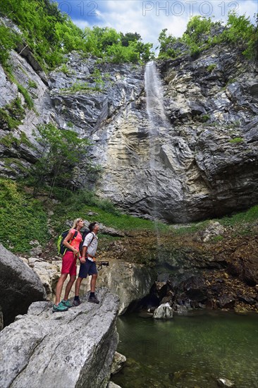 Hikers in front of the waterfall Schossrinn