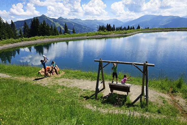 Family playing during a hike at the storage lake at the middle station