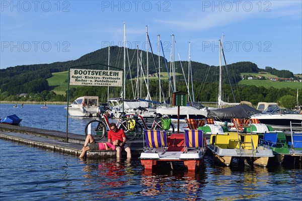 Couple with electric bikes pauses on a landing stage at Lake Obertrumer See