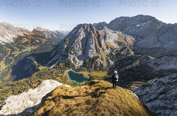 Young woman with climbing helmet looking at Seebensee from the Ehrwalder Sonnenspitze