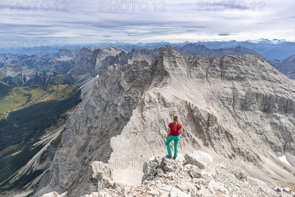 Woman standing on rocks and looking into the landscape