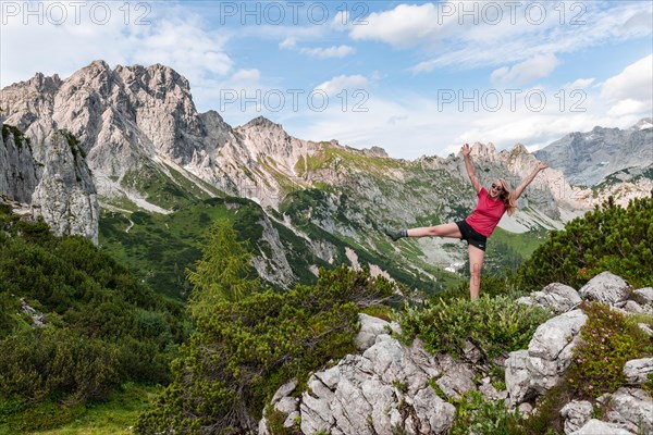 Young woman stretches arms in the air