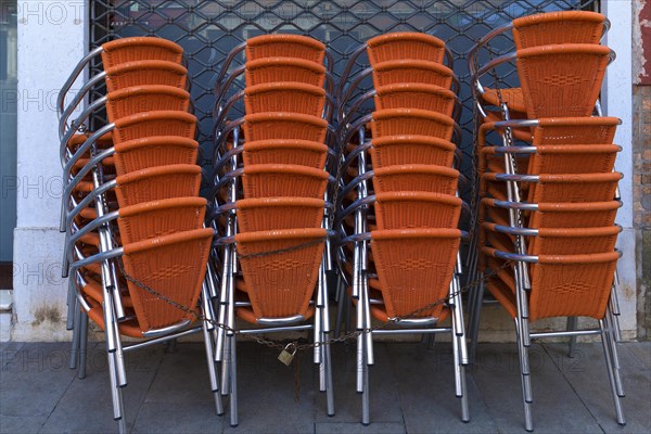 Locked stacking chairs in front of a restaurant