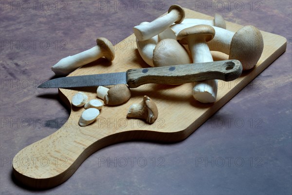 Seitlings on wooden board and knife