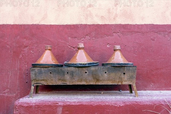 Three clay tagine pots on portable barbeque