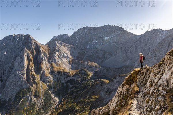 Mountaineer with climbing helmet stands on a rocky outcrop