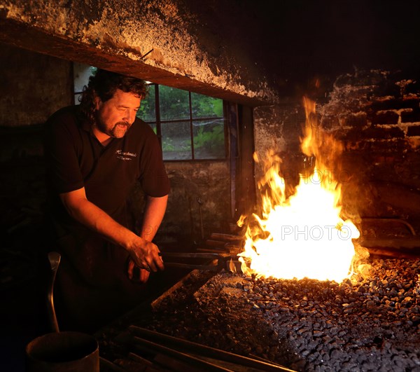 Blacksmith at the blacksmith's hearth