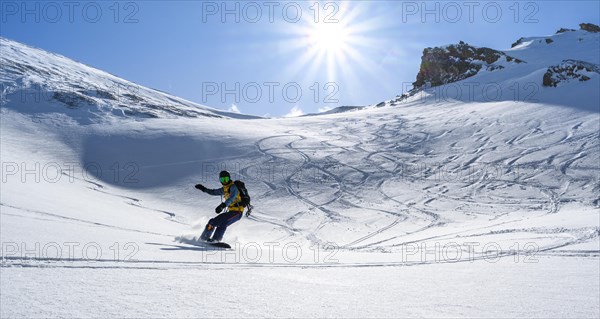 Snowboarder with splitboard rides in the snow