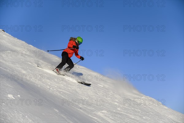 Skier descending steep slope