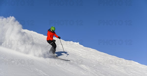 Skier descending steep slope