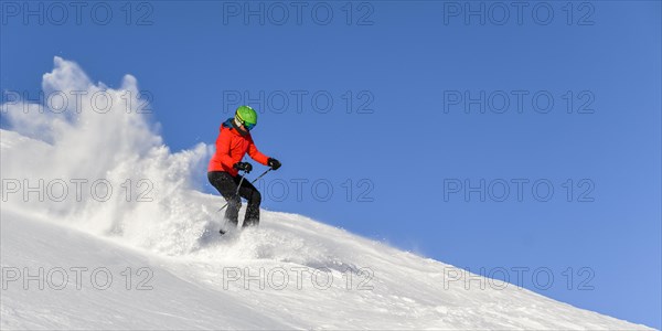 Skier descending steep slope