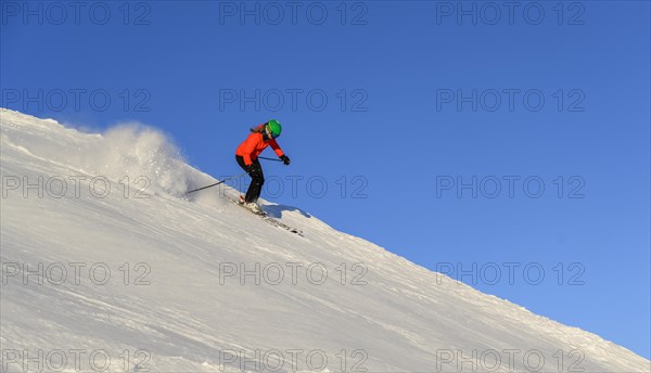 Female skier descending steep slope