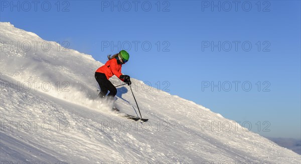 Female skier descending steep slope