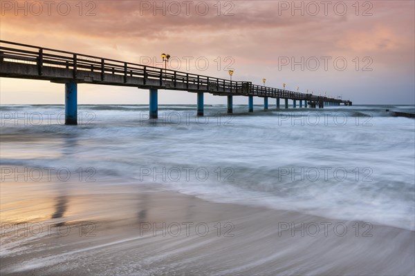 Pier on the beach of the Baltic Sea at sunset