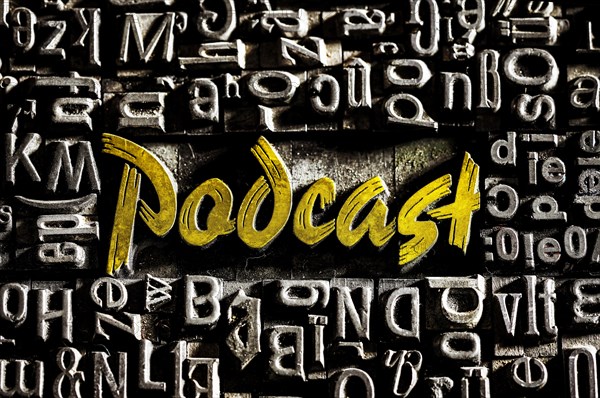 Old lead letters with golden writing show the word podcast