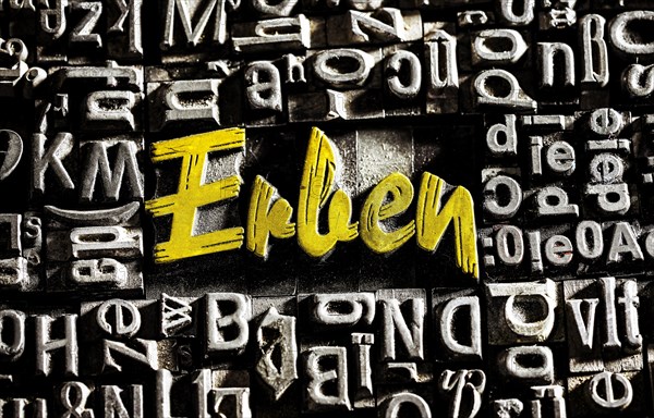 Old lead letters with golden writing show the word Erben